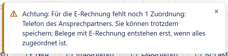 Eine Meldungskarte mit orangem Rand und Warnsymbol: »Achtung: Für die E-Rechnung fehlt noch 1 Zuordnung: Telefon des Ansprechpartners. Sie können trotzdem speichern; Belege mit E-Rechnung entstehen erst, wenn alles zugeordnet ist.« Rechts oben ein Kreuz.
